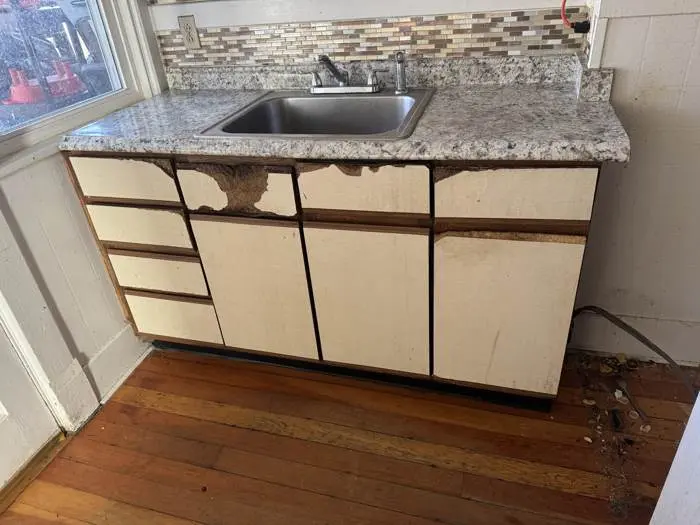 Damaged kitchen cabinets before repair